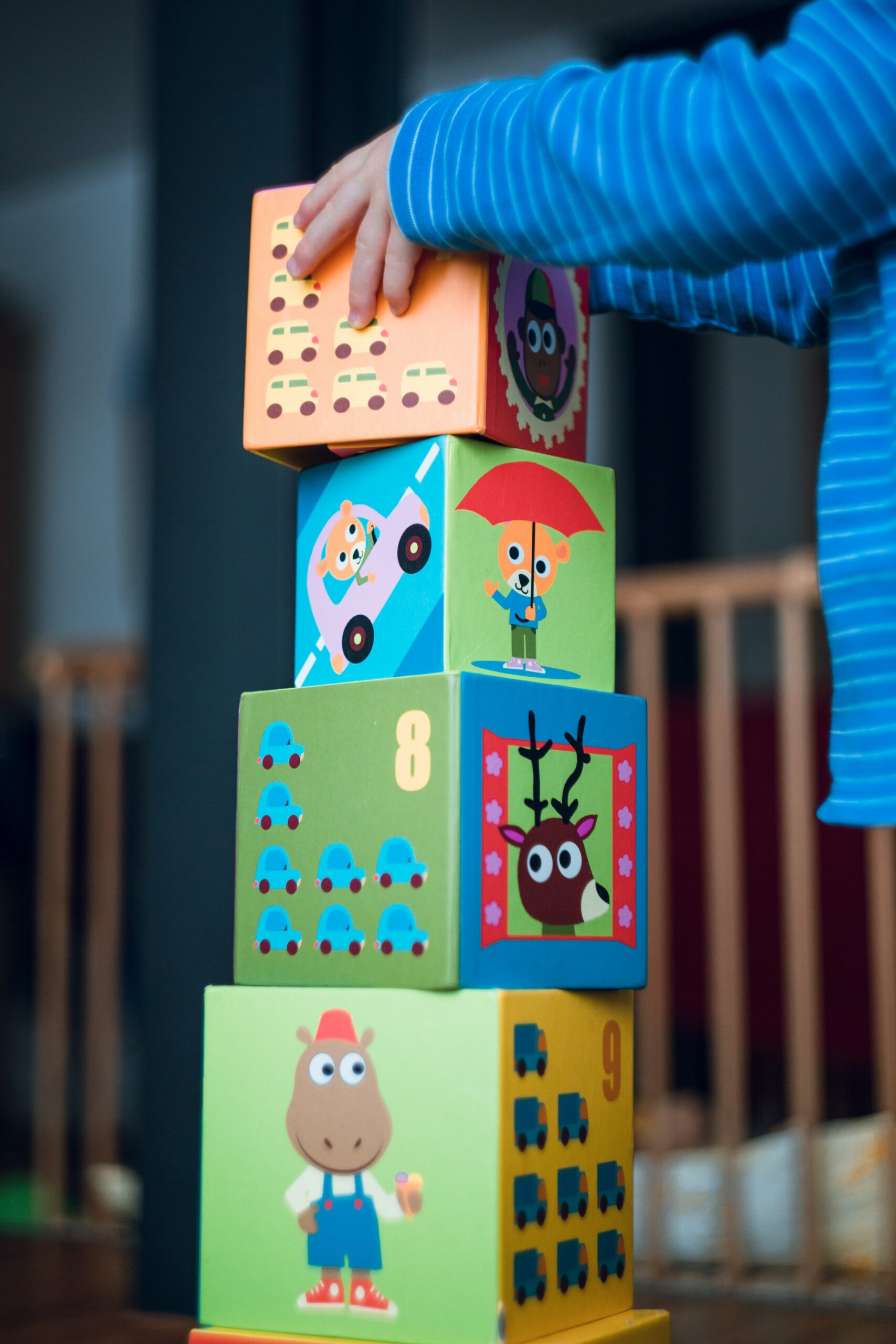 A toddler stacks blocks with both hands
