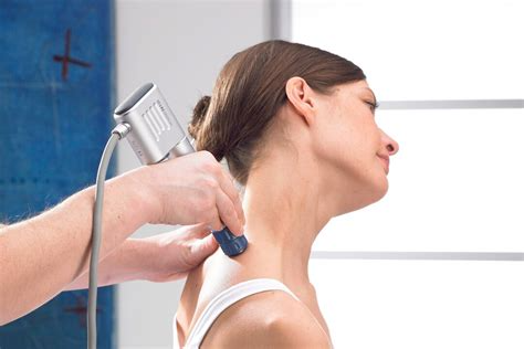 Extracorporeal shockwave therapy is applied to a female patient's right Levator Scapulae muscle